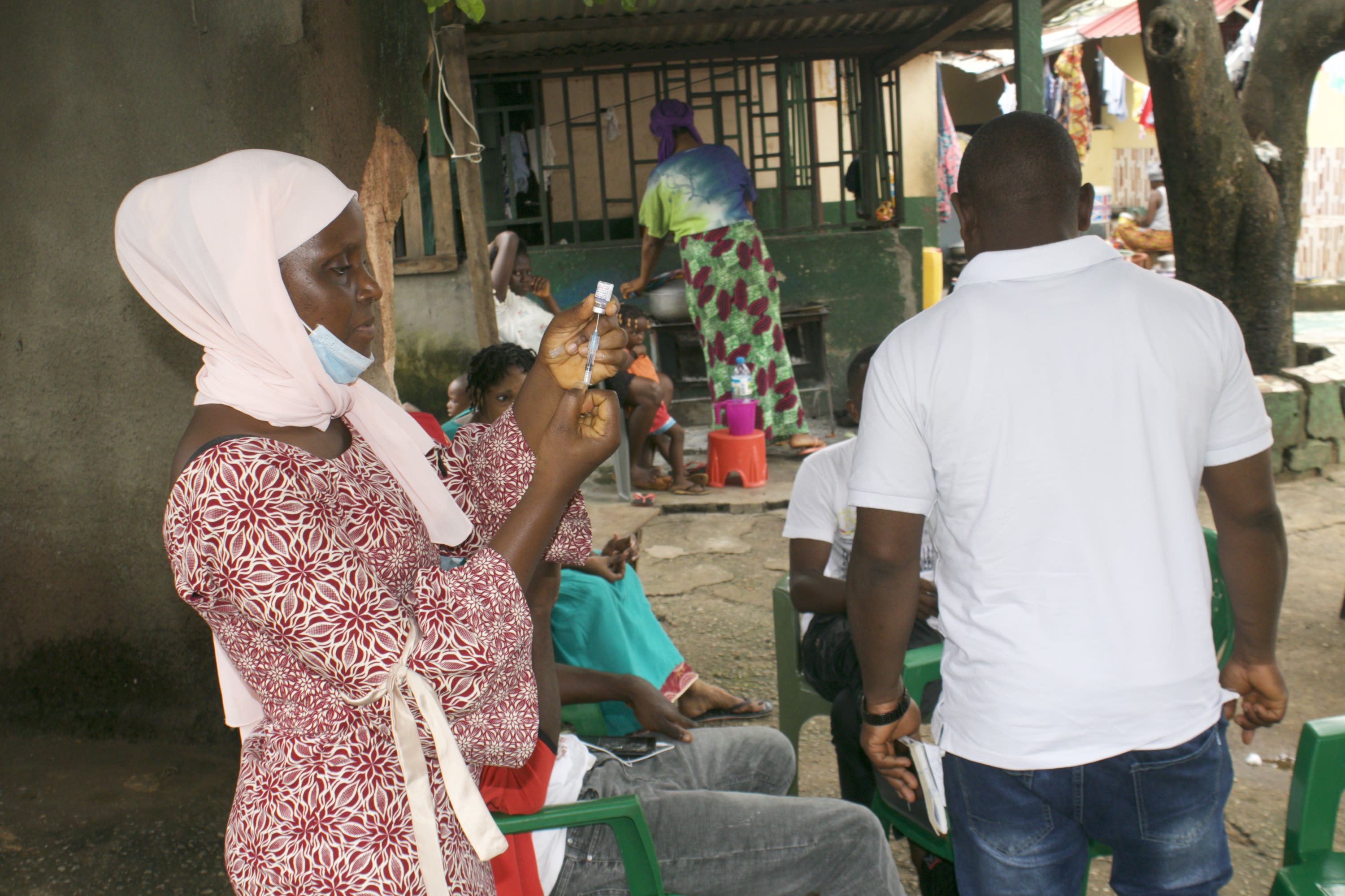 woman standing with syringe in hand